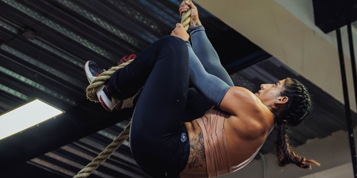 women climbing a rope during hyrox training