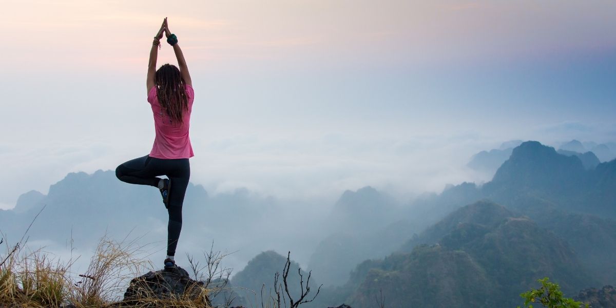 woman doing yoga on a mountain